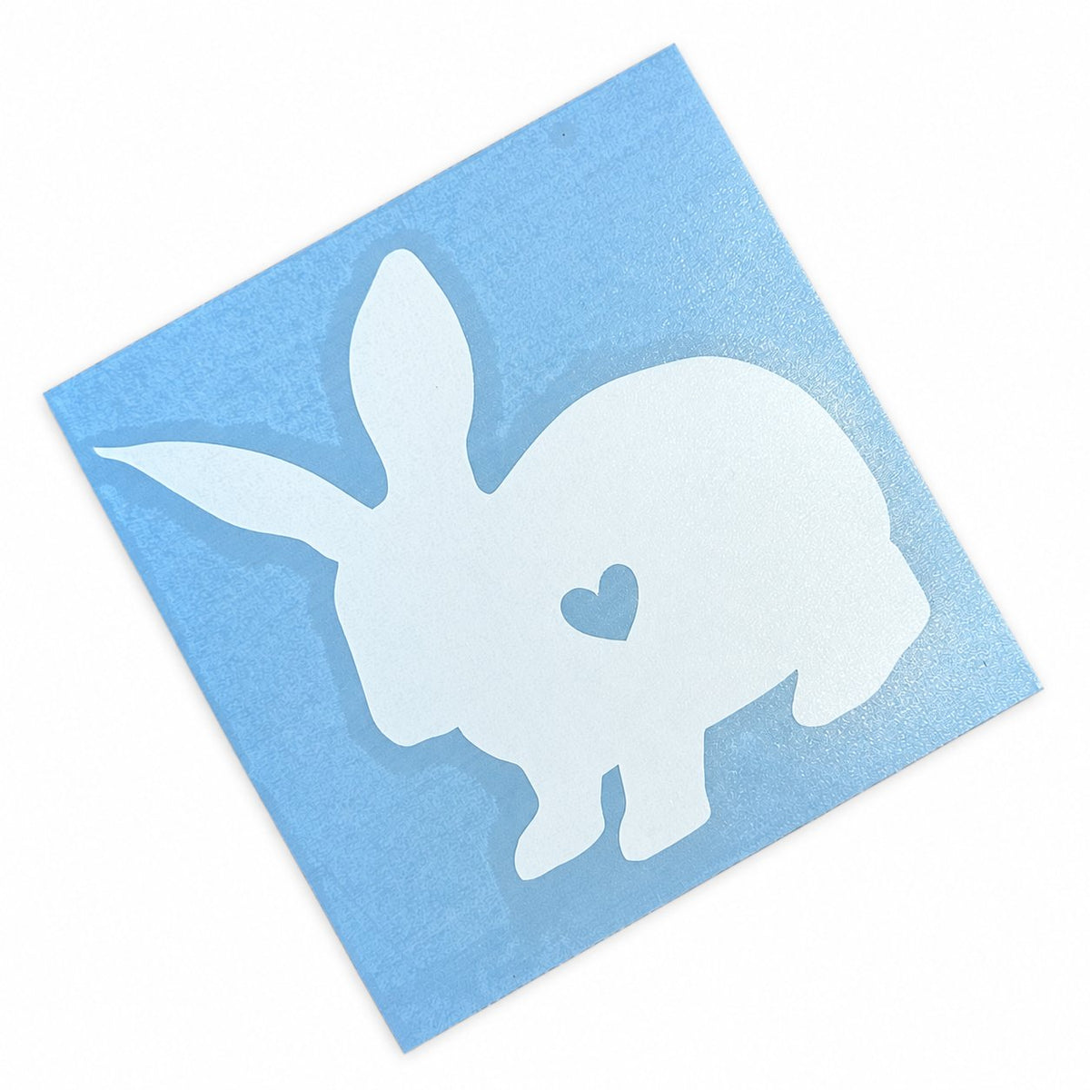 Collant lapin blanc avec cœur sur son support bleu, fond blanc