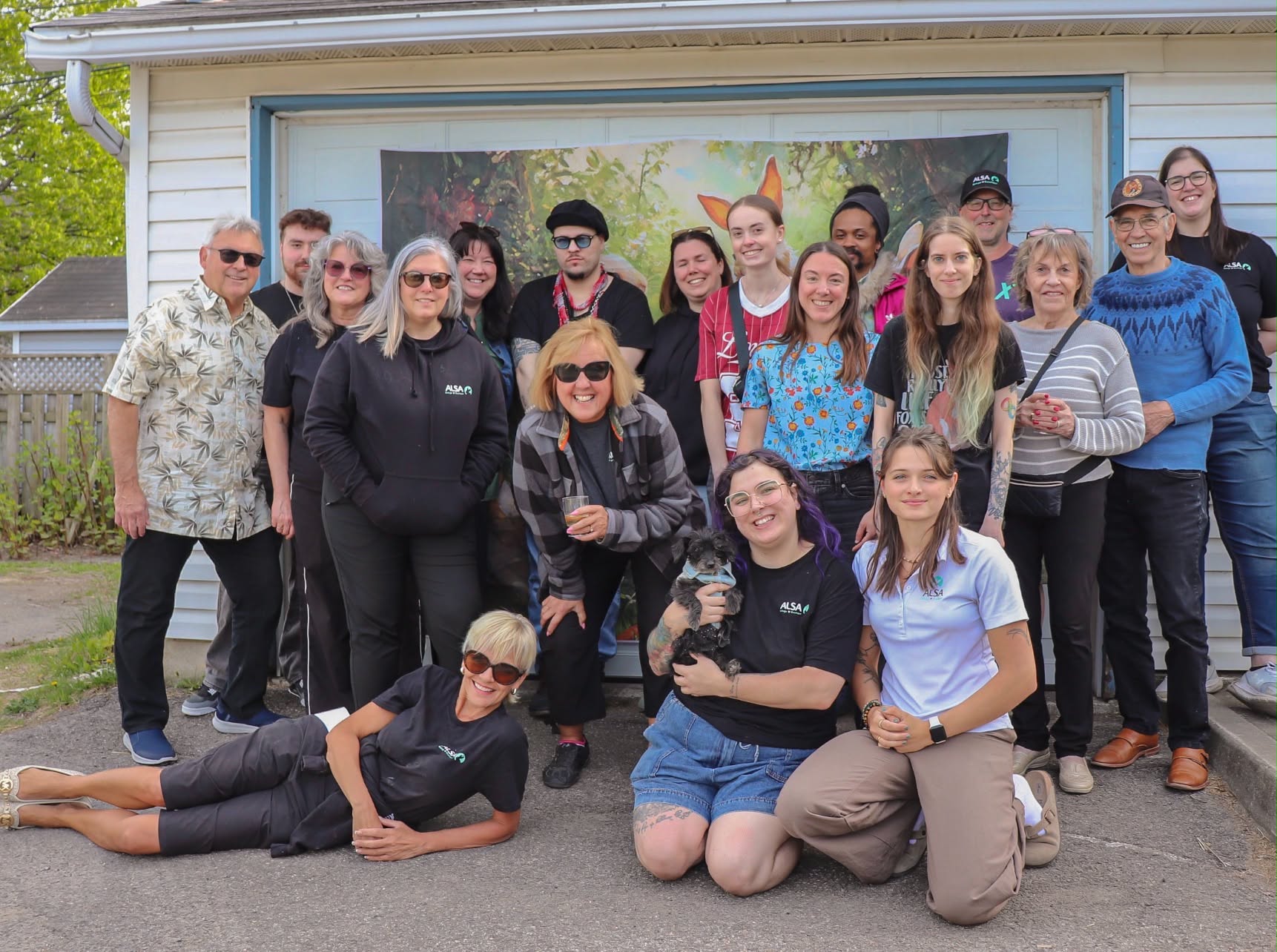 L’équipe du refuge ALSA réunie dehors pour une photo de groupe, avec un lapin dans les bras.